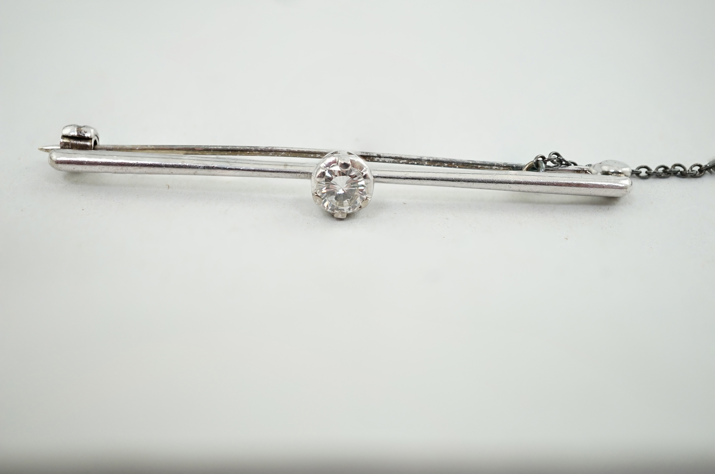 An 18ct white gold and illusion set solitaire diamond set bar brooch